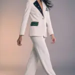 "La Julianne Blazer aporta una energía vibrante al tailoring clásico con un diseño audaz y contemporáneo. Confeccionada en un elegante azul marino, se realza con llamativos detalles en verde esmeralda que decoran las solapas, el bolsillo superior y las carteras, creando un contraste fresco y lleno de personalidad. Su silueta entallada y hombros estructurados estilizan la figura, mientras que los botones dorados añaden un toque sofisticado y luminoso. Los detalles gráficos con estrellas aportan un aire moderno y distintivo que convierte esta blazer en una pieza protagonista, perfecta para quienes buscan elegancia con carácter. Combínala con denim para un look relajado pero pulido, o con pantalones de sastrería para un estilismo más refinado. Versátil, poderosa y con un espíritu contemporáneo: una blazer diseñada para destacar en cualquier ocasión."